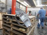 A 304 SST piece waits on top of some pallets to be fully assembled