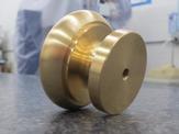 An up-close side view of a machined brass mushroom knob